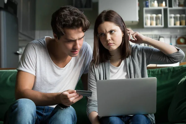 Молодая пара пользуется компьютером и кредитной картой дома — стоковое фото