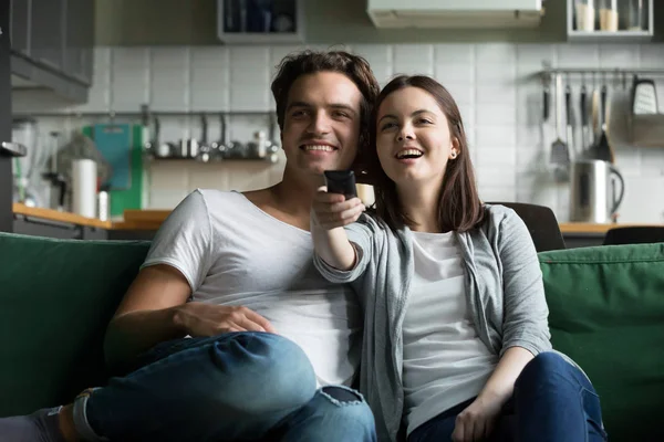 Couple watching tv sitting on couch at home — Stock Photo, Image