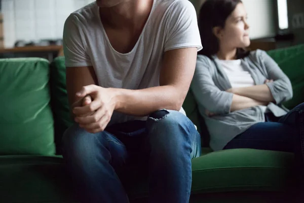 Unhappy couple sitting on couch at home — Stock Photo, Image