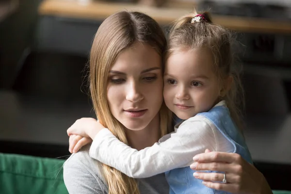 Petite fille préscolaire embrassant la mère fatiguée et bouleversée — Photo