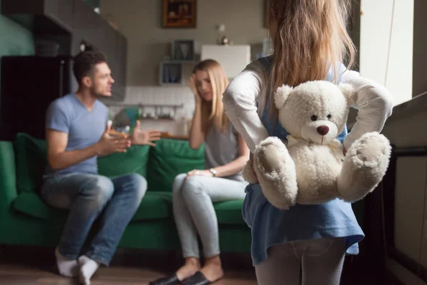 Rear view little girl holding toy while parents fighting — Stock Photo, Image