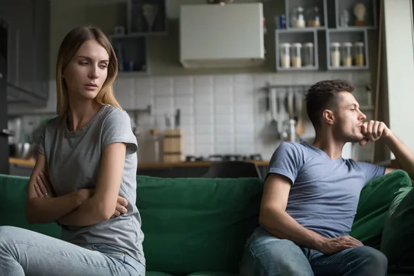 Offended upset man and woman sitting separately on couch — Stock Photo, Image