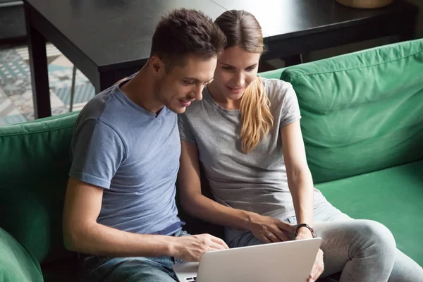 Захватывающие мужчина и женщина сидят вместе и используют ноутбук — стоковое фото
