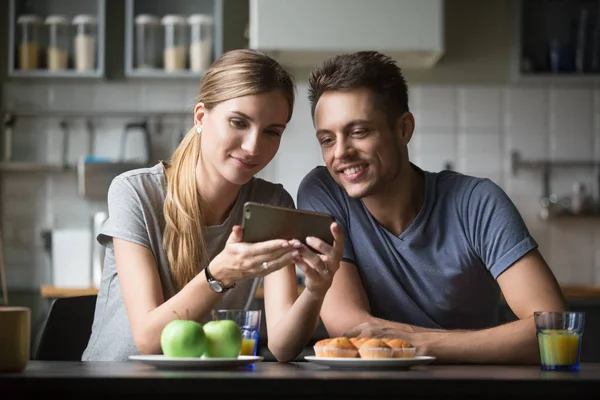 Молодая женщина показывает мужчине экран смартфона, видео, фотографии — стоковое фото