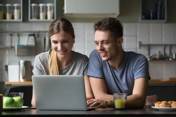 Счастливая улыбающаяся пара смотрит на экран ноутбука вместе — стоковое фото