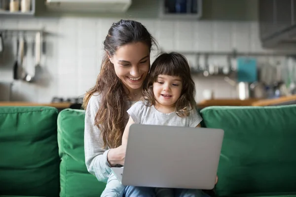 Happy laughing mother and daughter using laptop — Stock Photo, Image