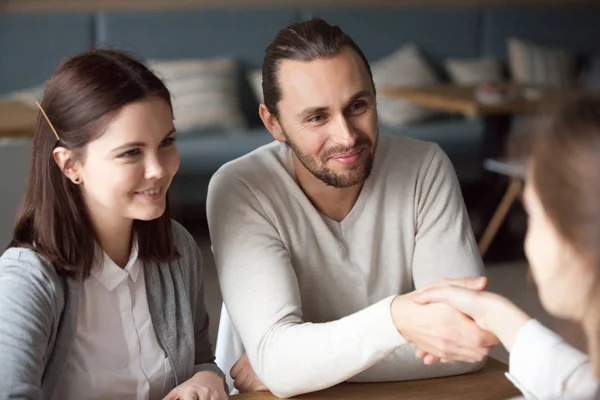 Happy millennial couple handshake realtor during meeting — Stock Photo, Image