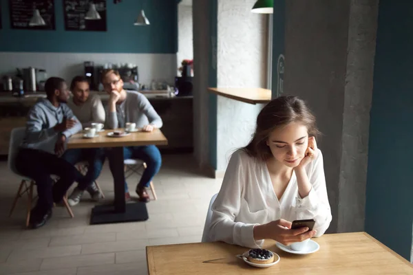 Молодые парни интересуются девушкой, сидящей рядом в кафе — стоковое фото