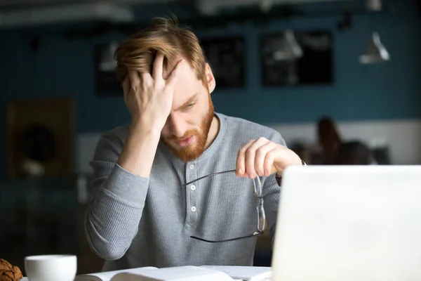 Cansado macho molesto con difícil estudiar sentado en la cafetería — Foto de Stock