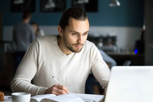 Estudante masculino focado estudando com laptop no café — Fotografia de Stock