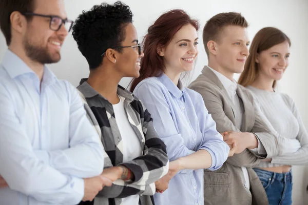 Giovani diversi che si tengono per mano mostrando unità e lavoro di squadra — Foto Stock