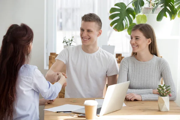 Happy millennial couple handshake broker meeting in office — Stock Photo, Image