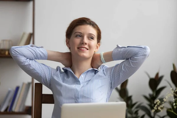 Mujer sentada en la oficina cogida de la mano detrás de la cabeza —  Fotos de Stock