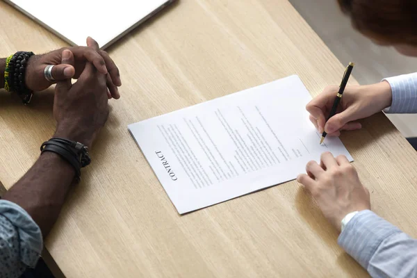 Diverse business people signing legal document on desk — Stock Photo, Image