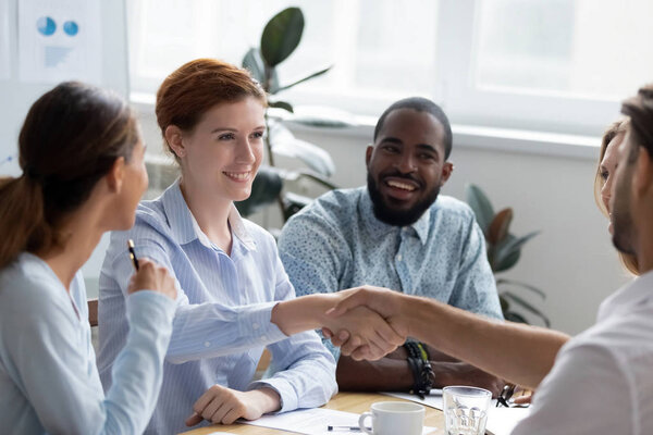 Multi-ethnic businesswoman shaking hands greeting company client
