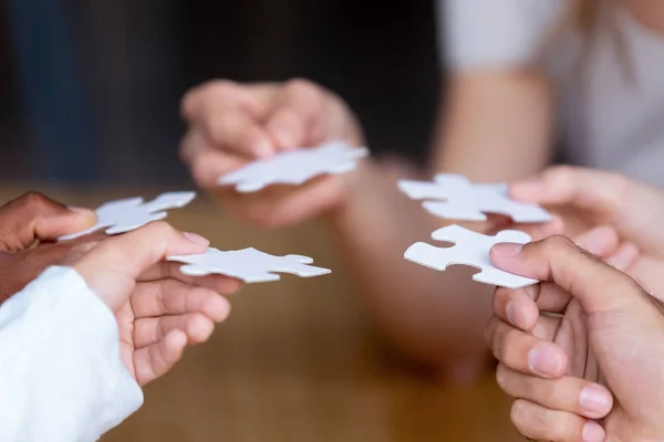 Hands of multinational people holding puzzle pieces — Stock Photo, Image