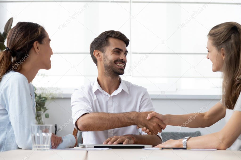 Male boss greeting female client before starting negotiations