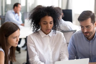 Ofis çalışanları ile dizüstü bilgisayar kullanarak Afrikalı-Amerikalı kadın lideri