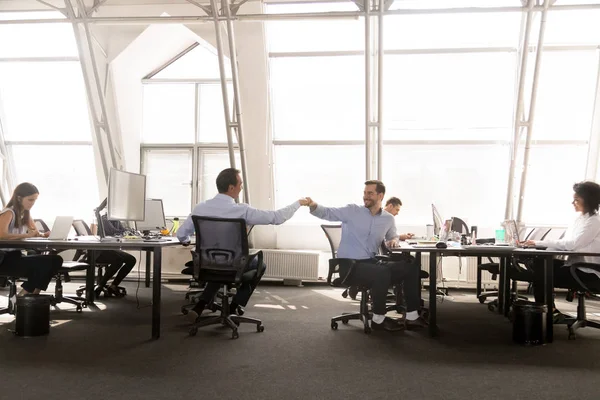 Amistosos colegas hombres puño chocando en el lugar de trabajo — Foto de Stock