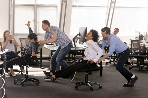 Excited diverse employees having fun together in office