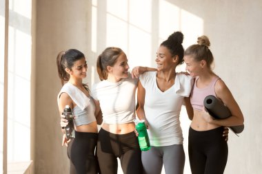Çeşitli genç kadınlar egzersiz yaptıktan sonra dinlenme konuşuyor