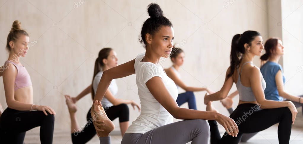 Mixed race girl doing One Legged King Pigeon pose