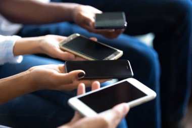 Çok ırklı insanların telefonları eller ekranında yakından gidiyor