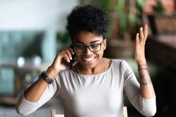 Happy African American woman excited about good phone conversati