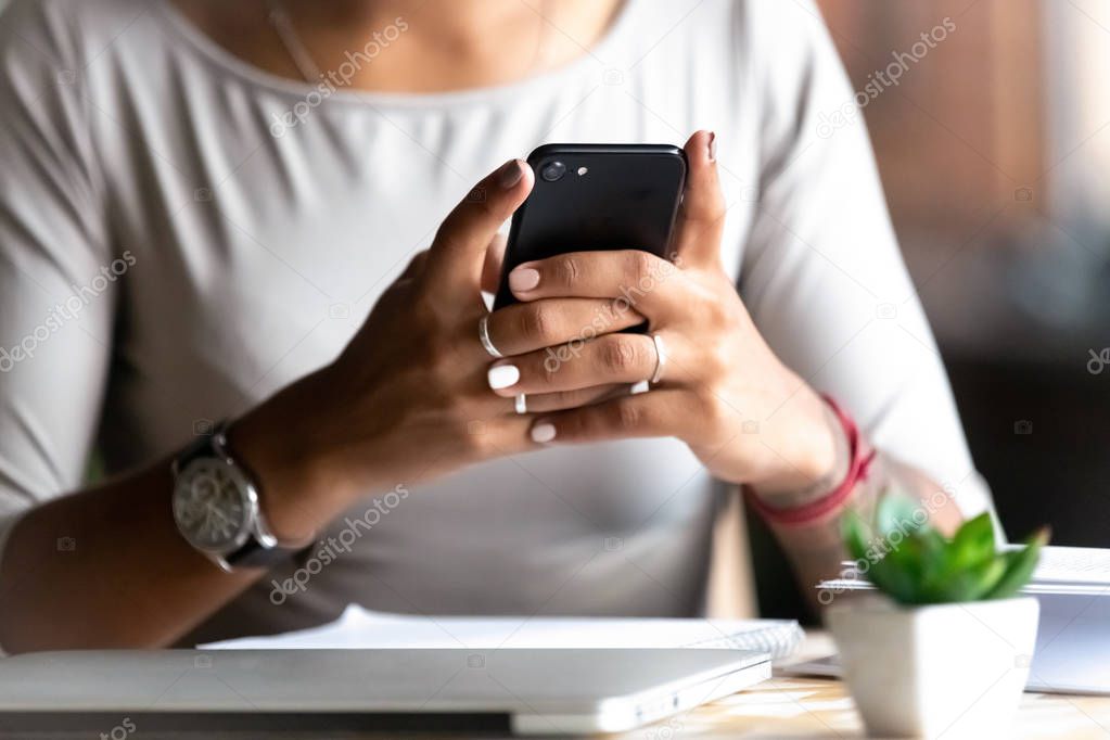 Close up woman holding smartphone, typing message