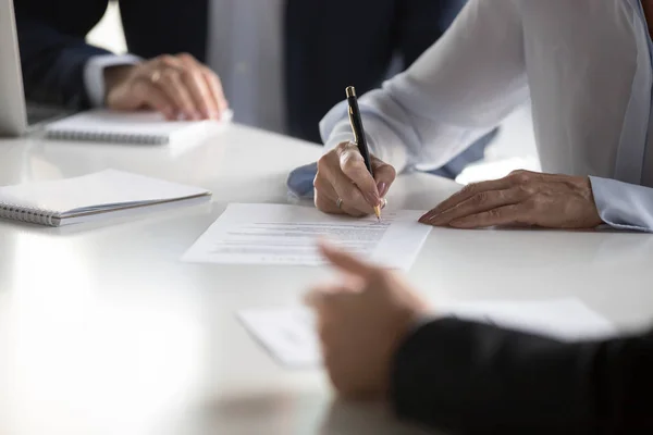 Close up female hands affirming contract with signature during m — Stock Photo, Image