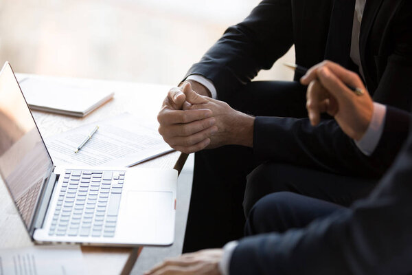 Close up businessmen in formal suits using computer working toge