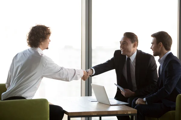 Young professional shaking hands with company HR manager