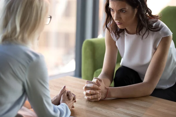 Women sitting staring at each other with distrust and animosity — Stock Photo, Image