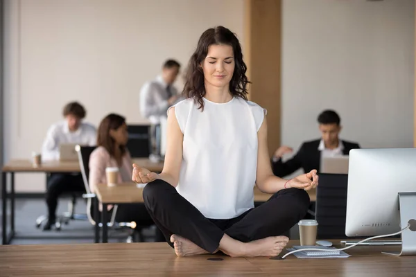 Barefoot employee meditating sitting in lotus position on office — Stock Photo, Image