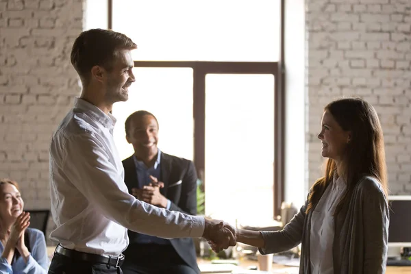 Male team leader handshaking female excited employee congratulat — Stock Photo, Image