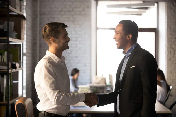 Vriendelijke Afrikaanse en Kaukasische werknemers handshaking, verwelkomen ne — Stockfoto