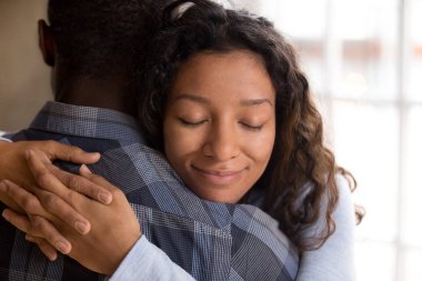 Happy african american wife hugging husband holding tight feelin clipart