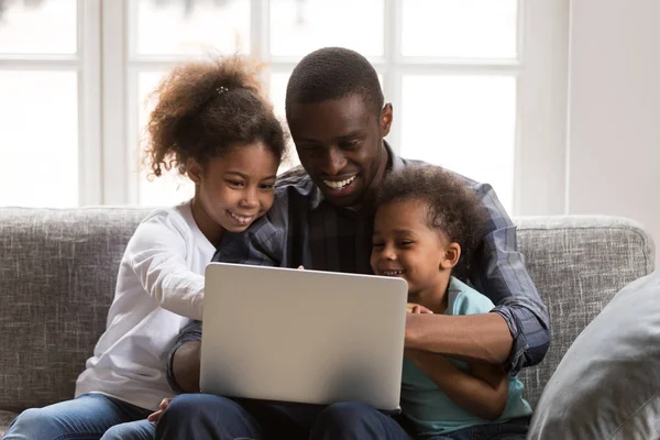 Felice padre africano e bambini utilizzando il computer portatile facendo negozio di famiglia — Foto Stock