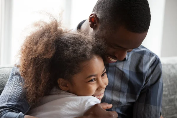 Mignon petite fille métissée embrassant papa africain aimant à la maison — Photo