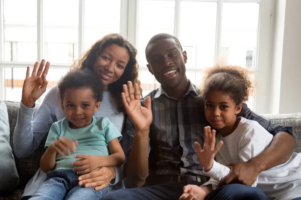 Famille africaine heureuse avec des enfants agitant les mains en regardant la caméra — Photo