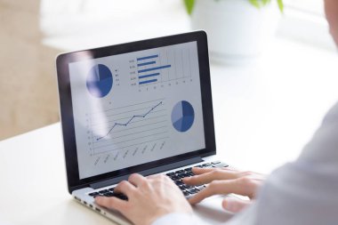 İş adamlarını dizüstü bilgisayar kullanarak kapatın, iş istatistiklerini analiz edin