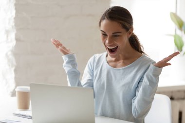 Excited woman using laptop, celebrating good news receiving