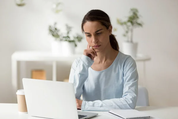 Serious female student using laptop, working on difficult projec — Stock Photo, Image