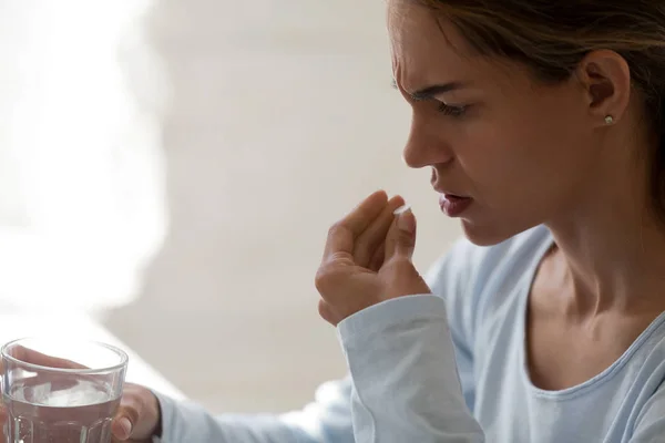 Cerca de la mujer malsana mantenga el vidrio quieto agua y píldora — Foto de Stock