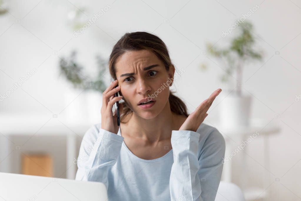 Upset unpleasantly surprised woman making phone call