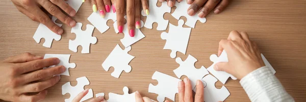 Top panoramic view hands of multinational people assembling jigsaw puzzle — Stock Photo, Image
