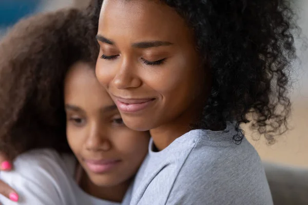 Närbild på svart mamma kramas tonårsdotter — Stockfoto