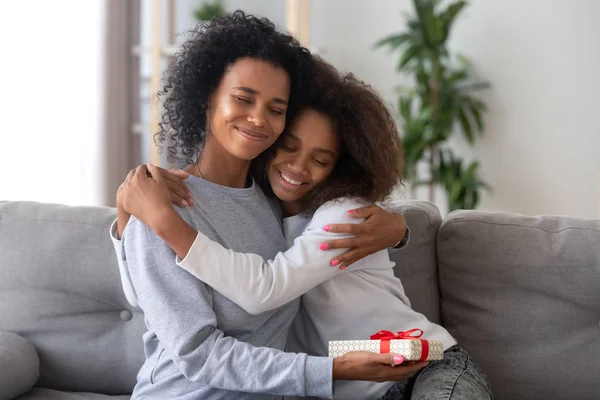 Happy mom hugging daughter thanking for present