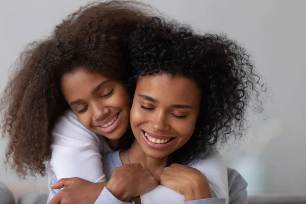 Kärleksfull tonårsflicka kram ung mamma bakifrån — Stockfoto