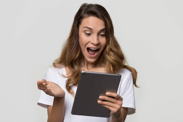 Stupito donna millenaria entusiasta di contenuti online guardando tablet — Foto Stock